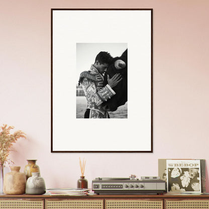 Framed black and white photo on pale pink wall, part of Triumphant Shadows Embrace