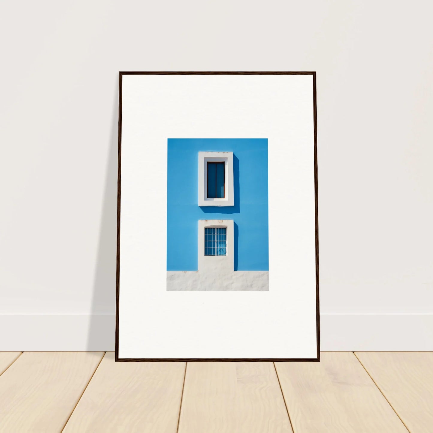 Framed wall art of Isles Encompassed Vista with bright blue wall and white windows