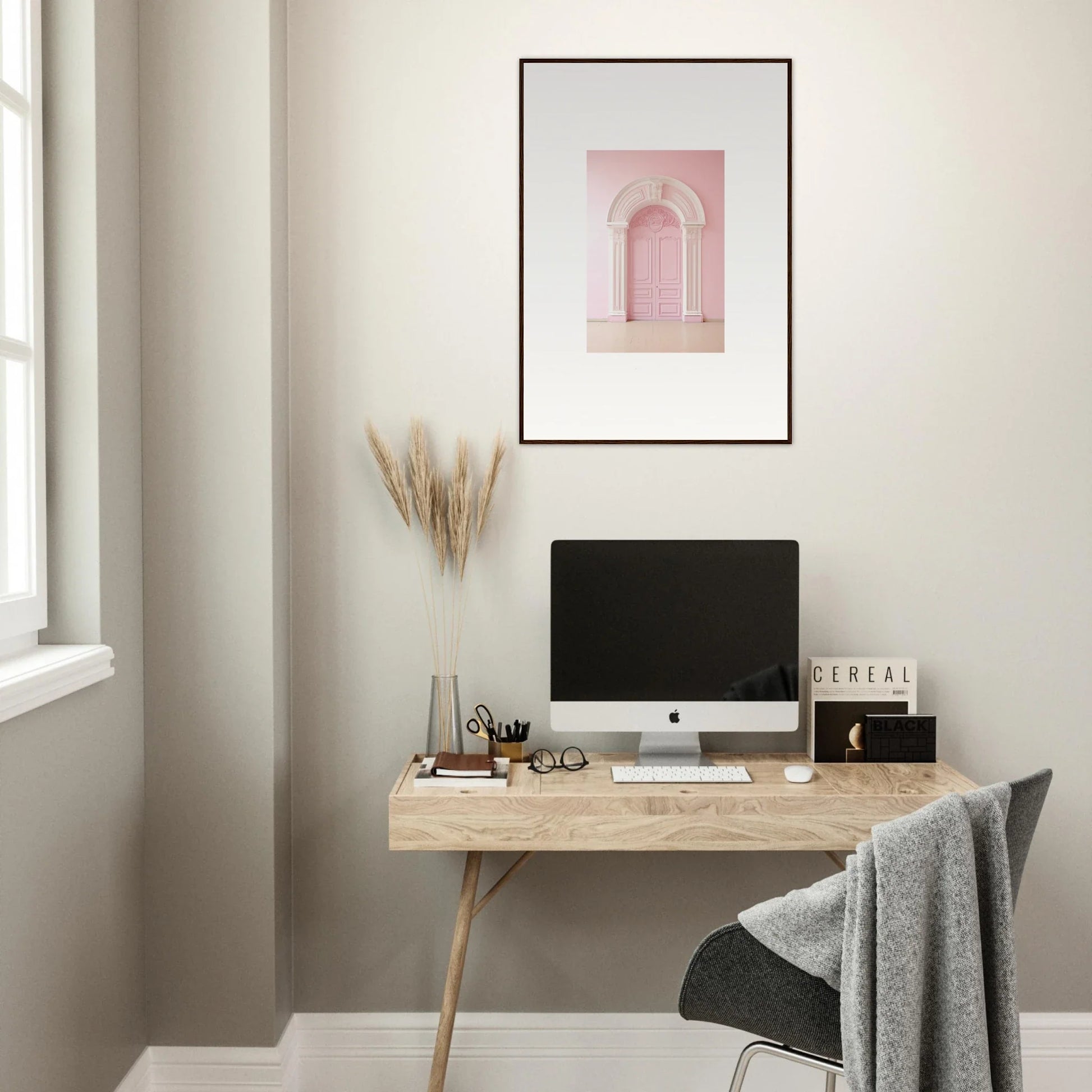 Minimalist wooden desk with an iMac and Portal Fantasies Unfurled framed wall art