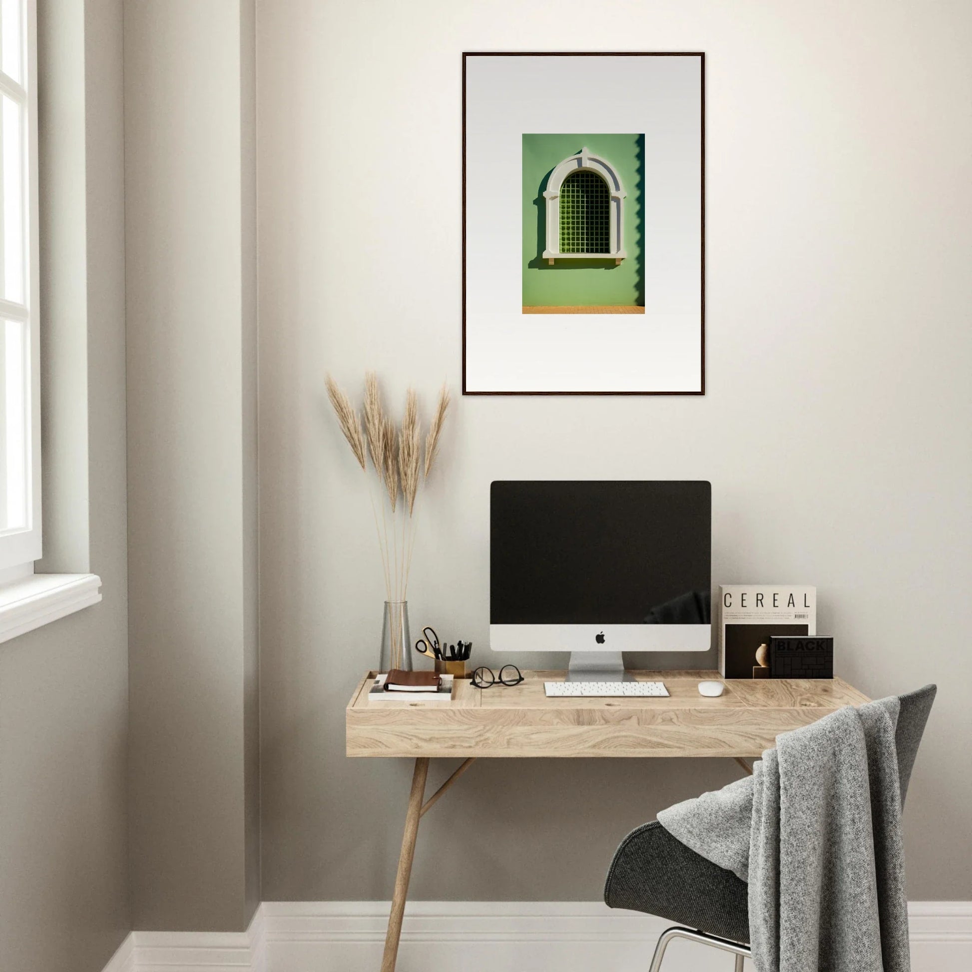 Minimalist wooden desk with an iMac and framed artwork above Visible Equilibrium Window