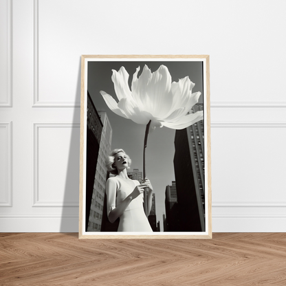 A white flower in a frame on a wooden floor