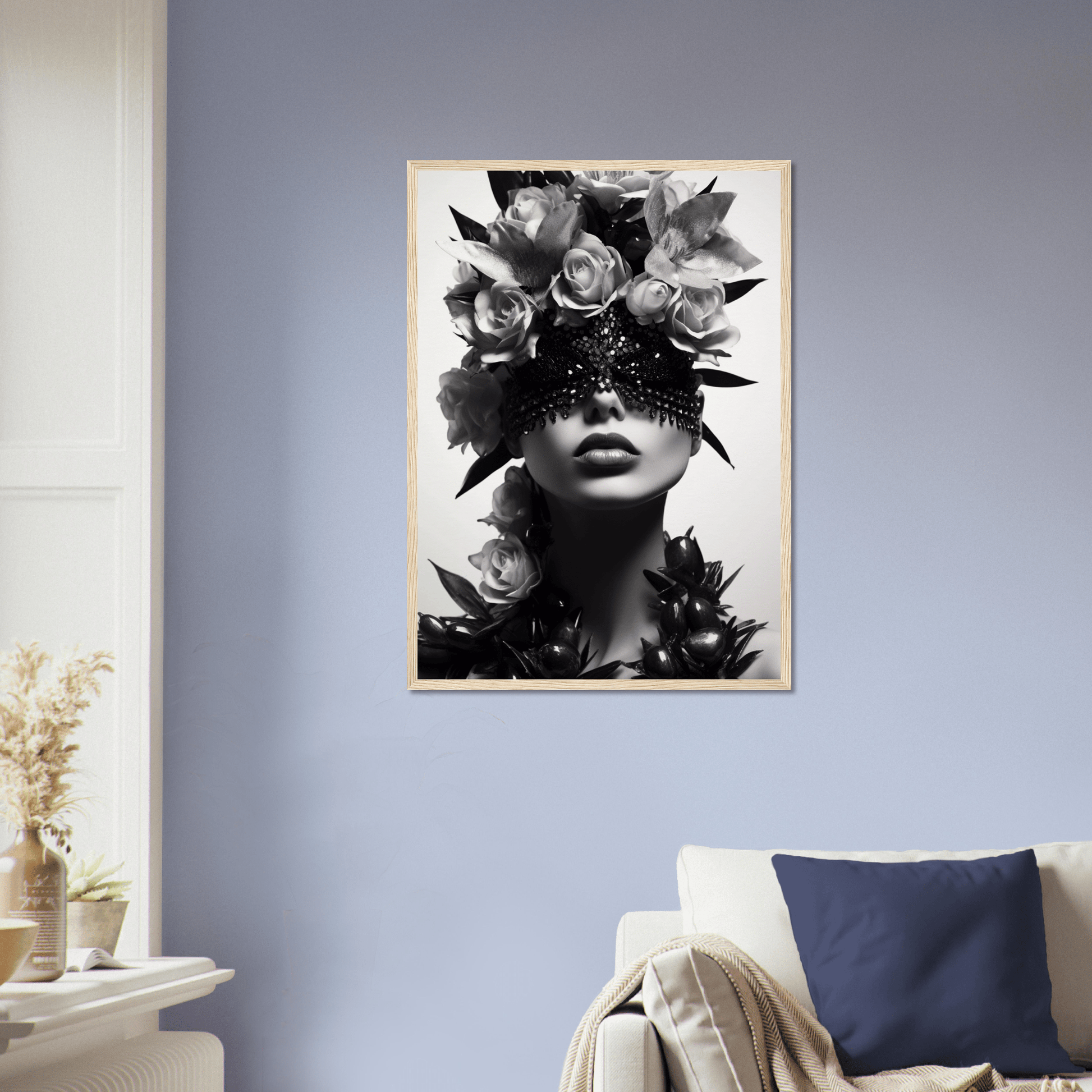 Framed black and white portrait of a figure adorned with floral headpiece and ornate eye covering.