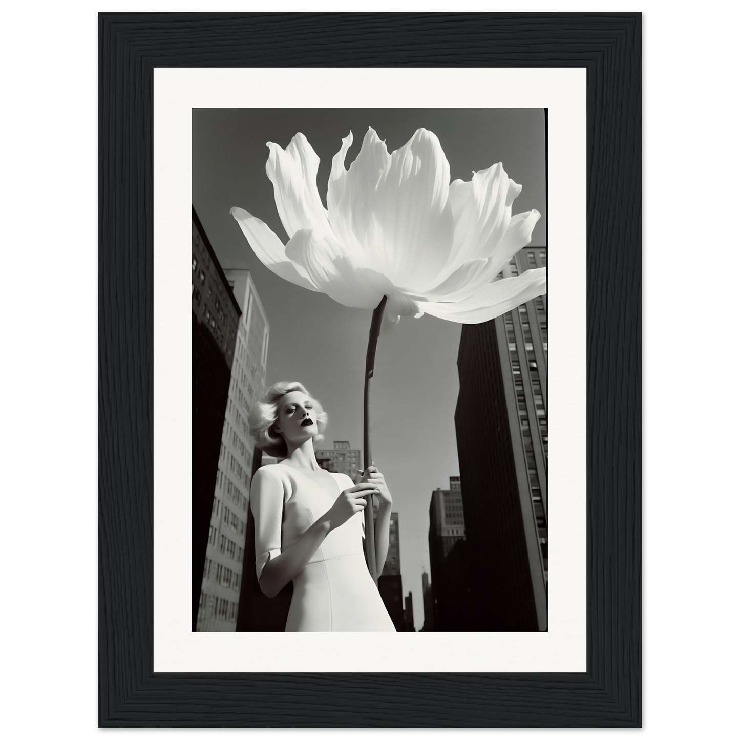 A woman holding a large white flower in front of a tall building