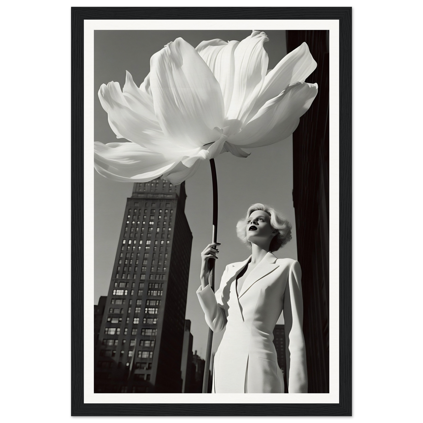 A woman holding a large white flower in front of a tall building