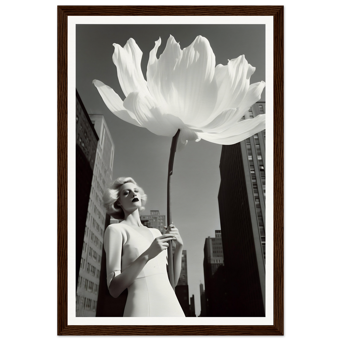 A woman holding a large white flower in front of a tall building