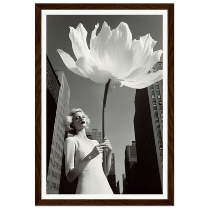 A woman holding a large white flower in front of a tall building