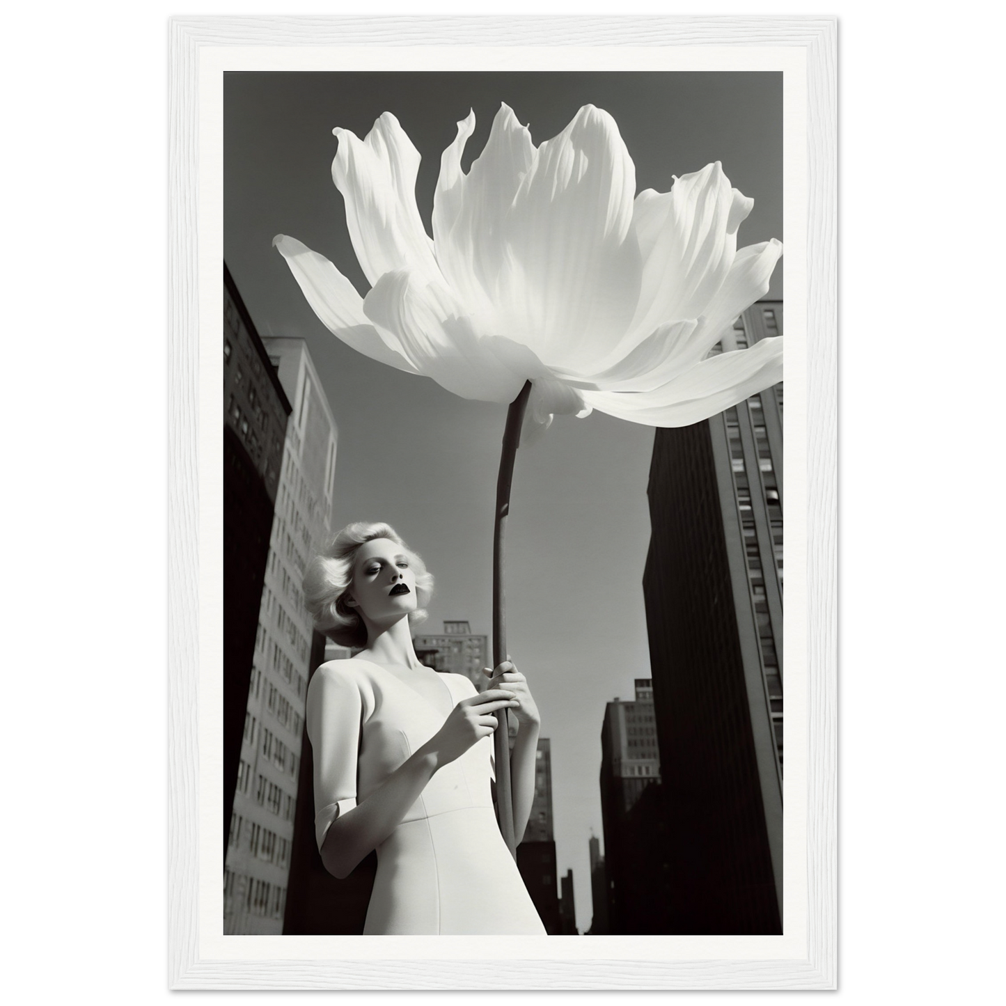 A woman holding a large white flower in front of a tall building