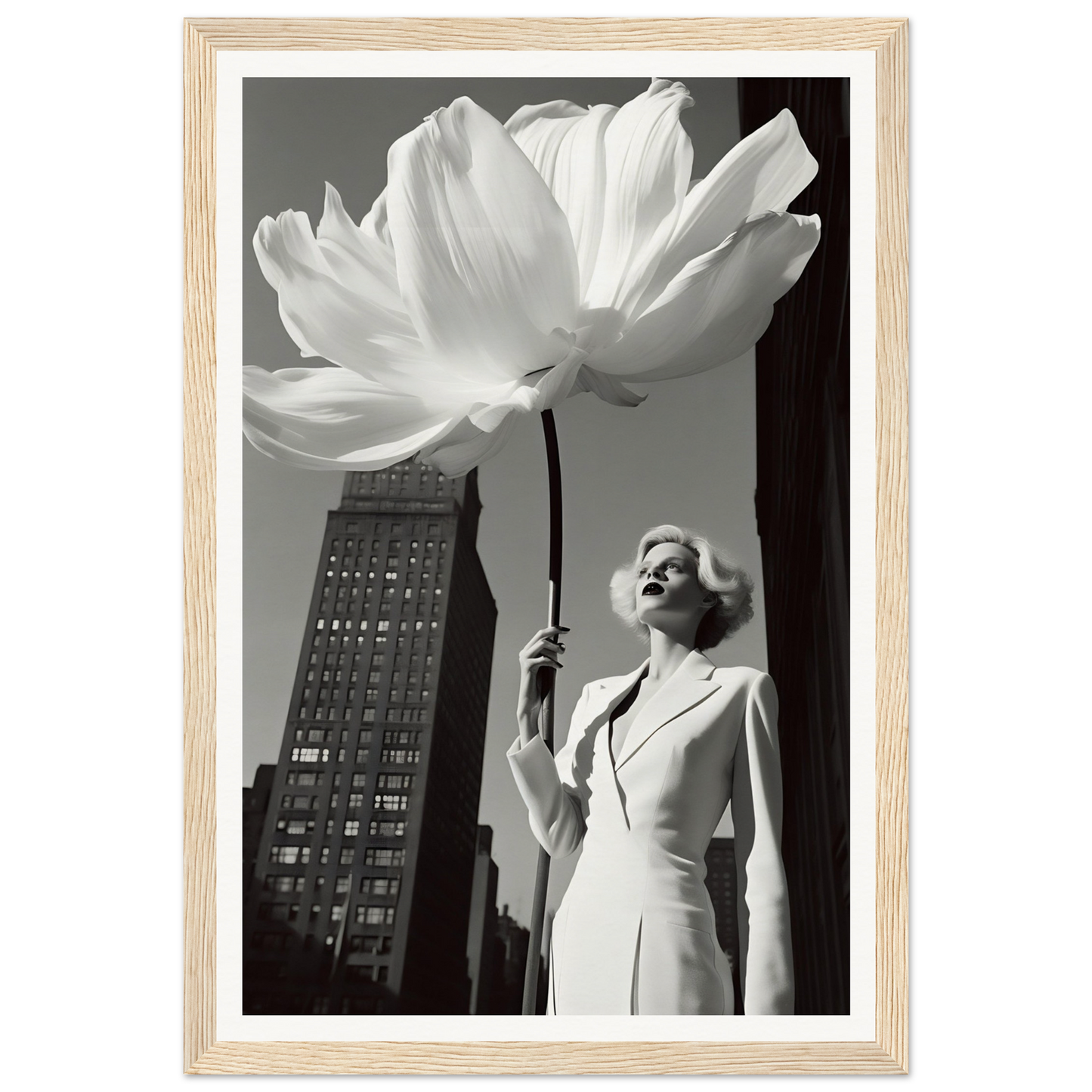 A woman holding a large white flower in front of a tall building